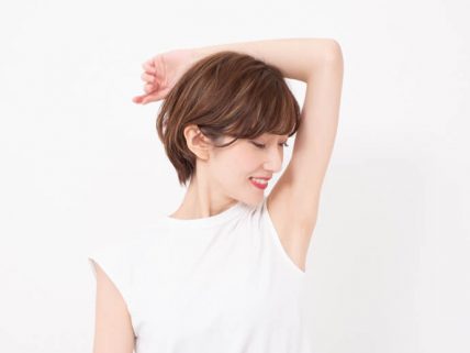 自分の脇を見る女性