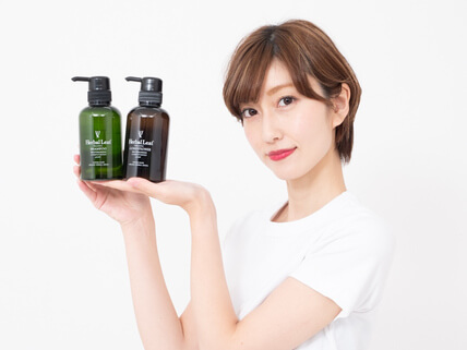 ハーバルリーフオーガニックシャンプーを持つ女性