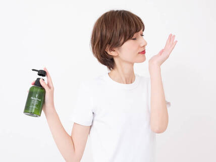 ハーバルリーフオーガニックシャンプーの匂いを嗅ぐ女性