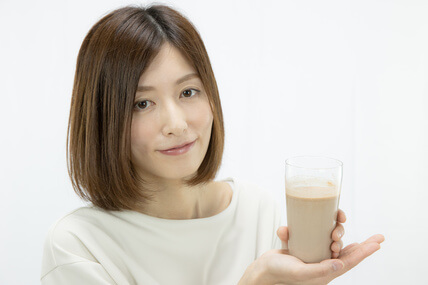 ロハスソイプロテインが入ったコップを持つ女性